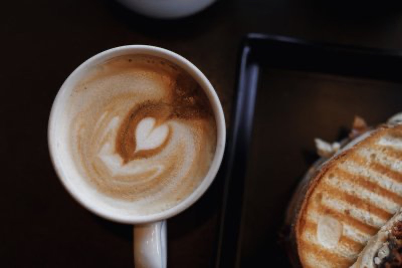 Cappuccino beside a grilled panini