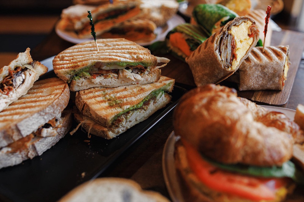 Grilled paninis and wraps stacked on serving trays