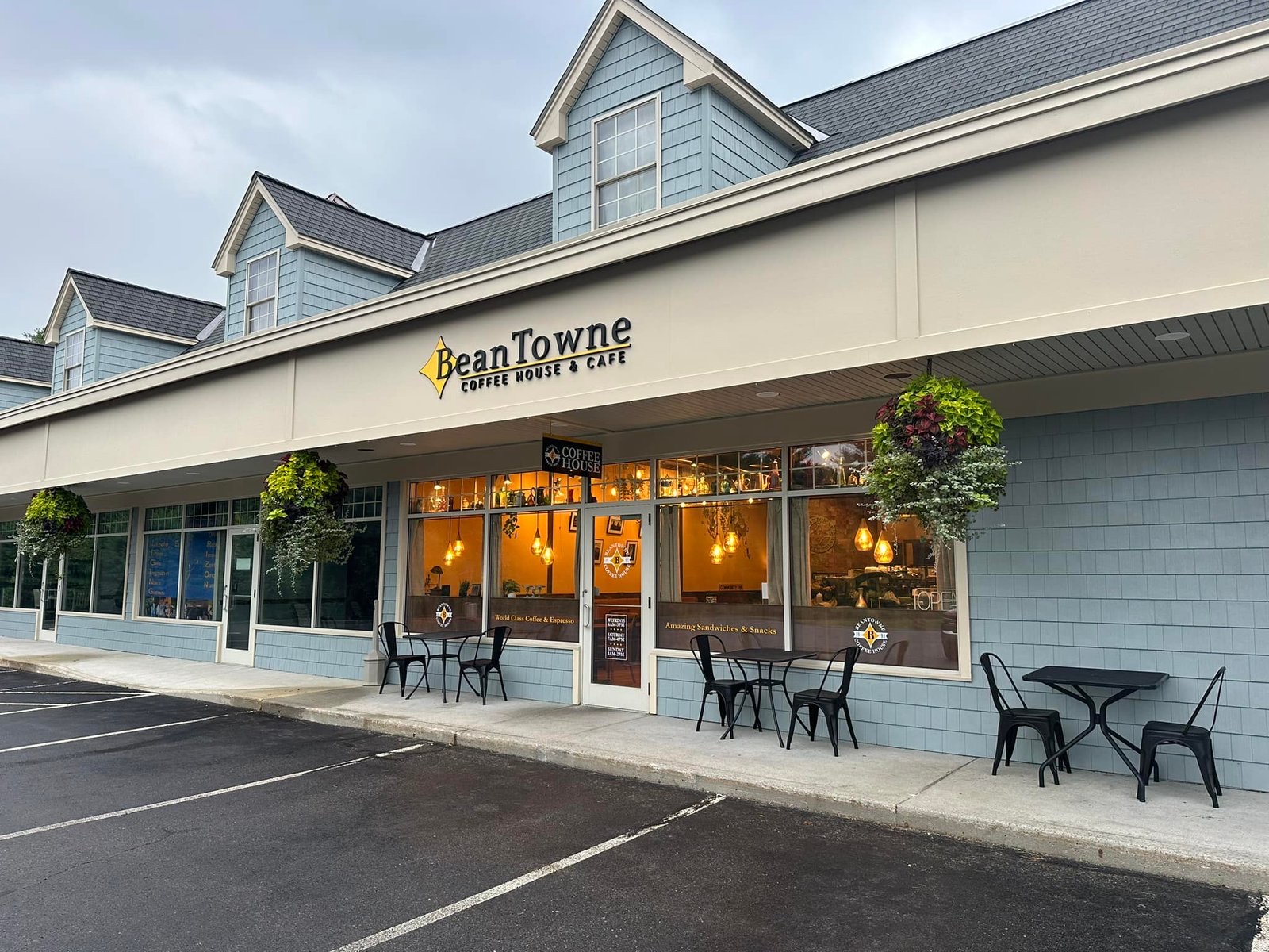 BeanTowne Coffee House storefront in Hampstead, NH, with café tables and hanging flower baskets